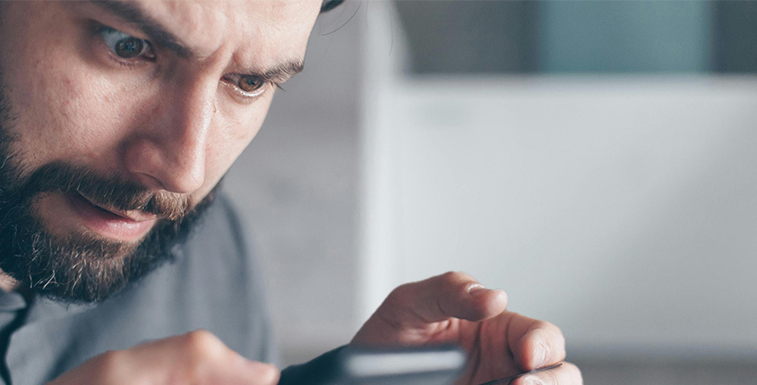 Frustrated man looking at his phone